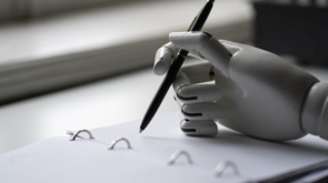 artificial robotic arm write down some notes with pen