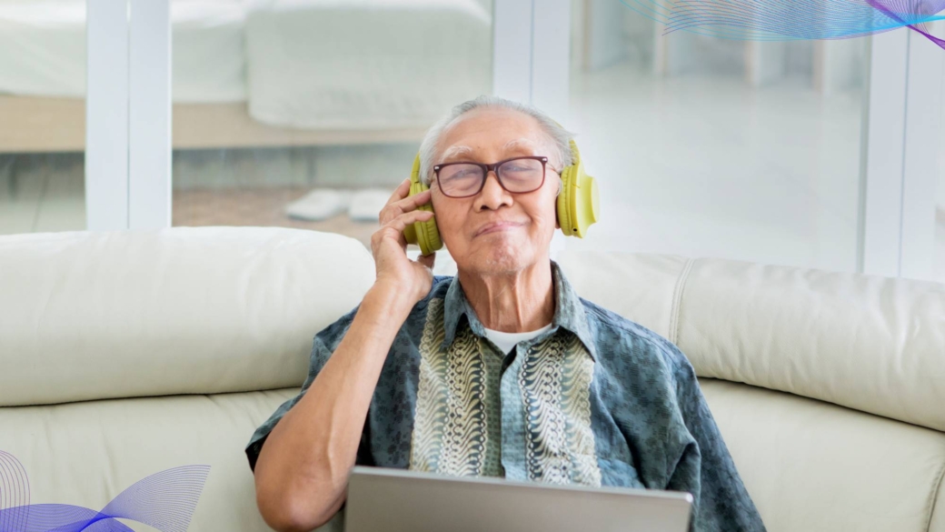 A imagem possui um idoso com fone de ouvido headset na cor amarela.