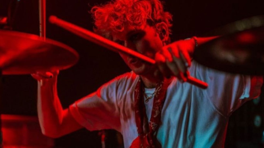 artista tocando bateria sob show de luzes vermelha enfrentando o desafio para artistas se destacarem