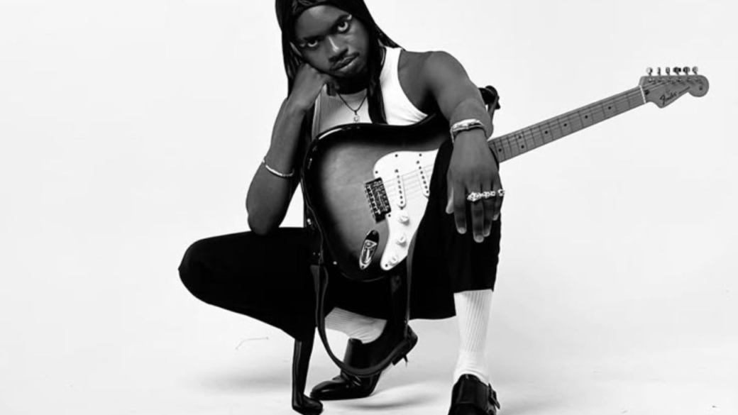 promovendo música de forma independente: artista com guitarra no colo sob fundo branco